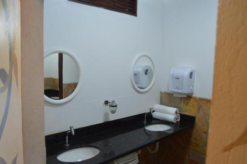 a bathroom with two sinks and two mirrors at Pousada Cavalo Marinho in Pipa