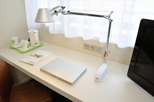 a desk with a lamp and a laptop on it at Campanile Lorient - Lanester in Lanester