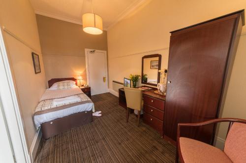 a bedroom with a bed and a dresser at Muthu Royal Thurso Hotel in Thurso