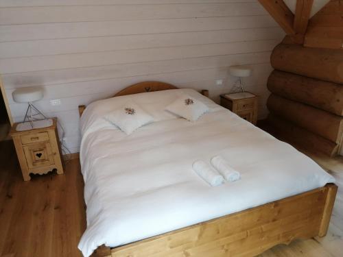 a bedroom with a bed with white sheets and pillows at Chalet le Dorf in Nötsch