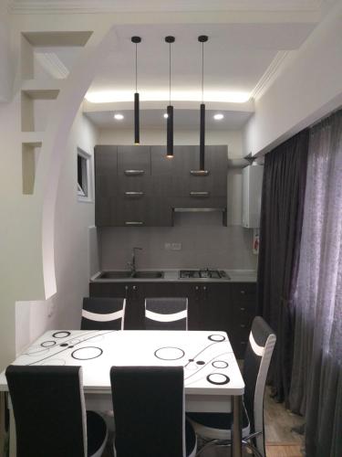 a kitchen with a white table and chairs in a room at Apartment for you in Tbilisi City