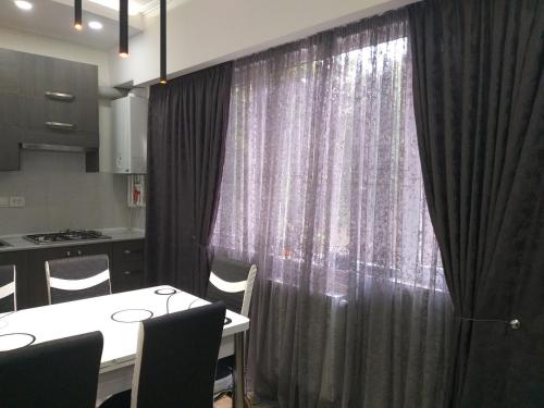 a dining room with a table and a curtain at Apartment for you in Tbilisi City
