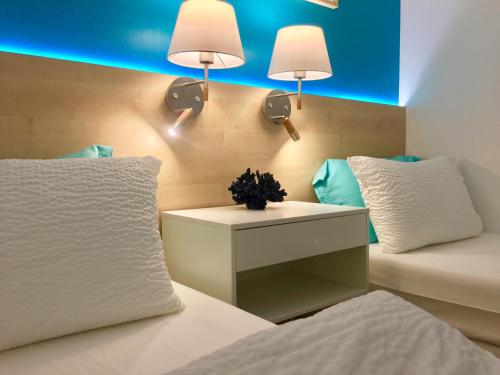 - une chambre avec un lit et deux lampes murales dans l'établissement MyHome Riviera - Cannes Sea View Apartment Rentals, à Cannes