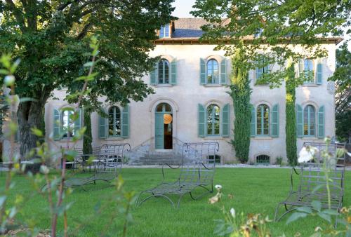 a group of chairs in front of a house at Couvent de la Salette & Spa in Millau