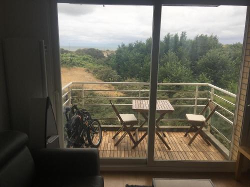 a view of a balcony with a table and chairs at Les pieds dans le sable in Malo-les-Bains
