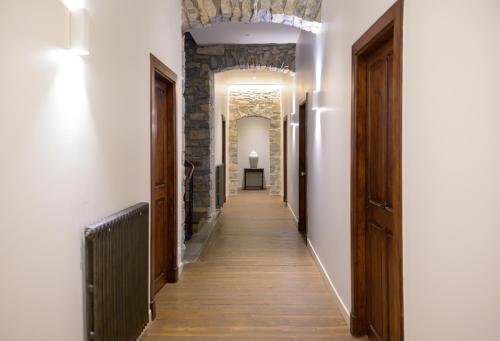 a hallway with wooden floors and a stone wall at Couvent de la Salette & Spa in Millau