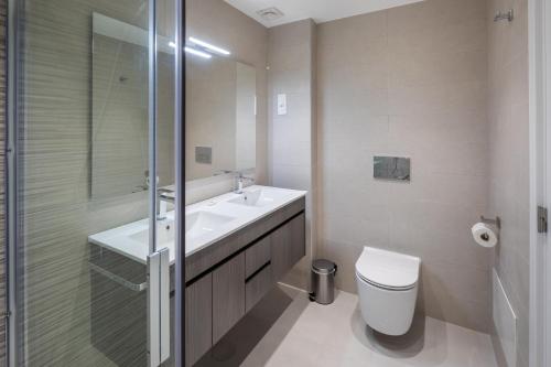 a bathroom with a toilet and a sink and a shower at Victory Village Sea Views in Quinta do Lago