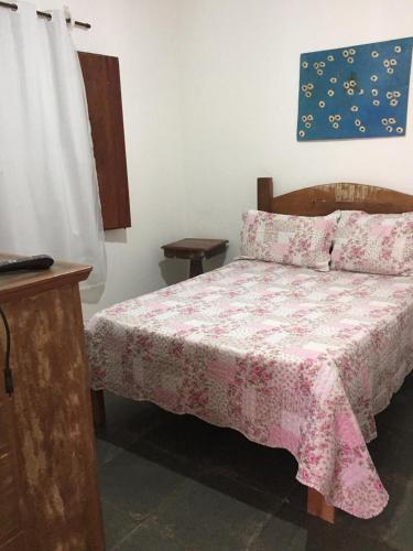 a bedroom with a bed with a pink blanket at Casa Recanto dos Encantos! in Tiradentes