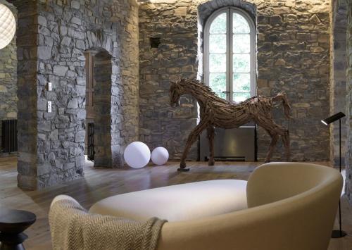 a statue of a horse in a room with a couch at Couvent de la Salette & Spa in Millau