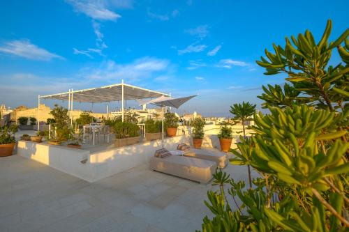 un patio con sofás y macetas en la parte superior de un edificio en Pascaraymondo Suite Palace, en Gallipoli