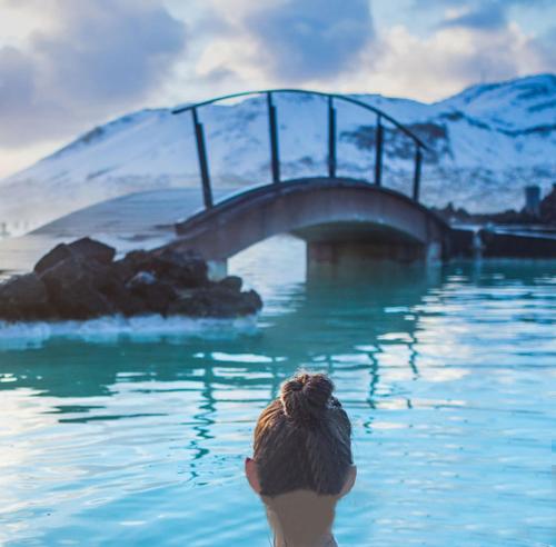 a person standing in the water near a bridge at Departamentos Exclusivos Termas de Chillán in Nevados de Chillan