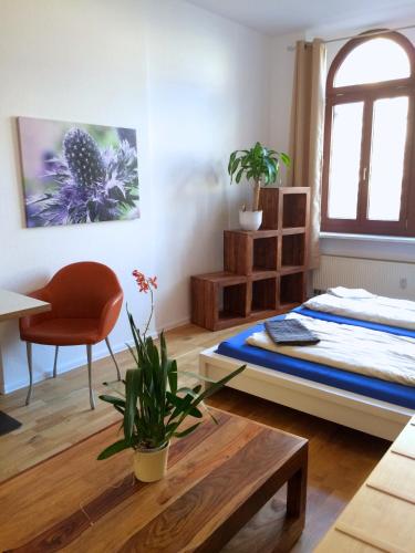 a bedroom with a bed and a table and a chair at Gwuni Mopera in Leipzig
