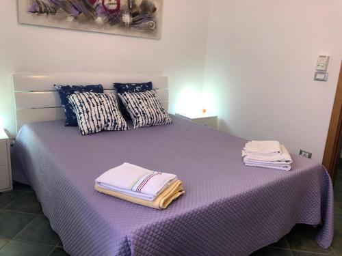 a purple bed with towels on top of it at villa per sole mare e relax in Alcamo Marina