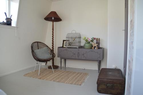 een kamer met een stoel en een tafel met een lamp bij Bijzonder Bakkum in Castricum