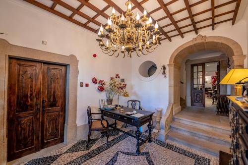 uma sala de jantar com uma mesa e um lustre em Casa Amarela TH & National Monument em Castelo de Vide