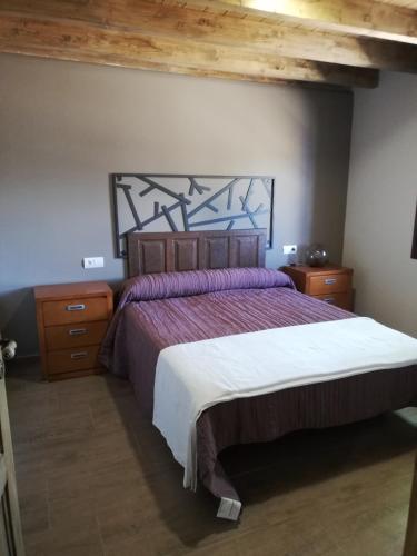 a bedroom with a large bed and wooden ceilings at Albergue la Medina de Camponaraya in Camponaraya