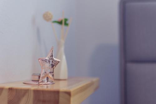 a table with a star and a vase with a flower at ART Hostel in Tirana