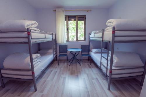a room with three bunk beds and a table at ART Hostel in Tirana