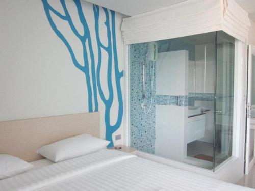 a bedroom with a blue painting on the wall at R-Con Blue Ocean in Pattaya