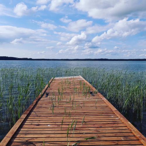 a wooden dock in the middle of a body of water at Sterla - Masuria in Giżycko