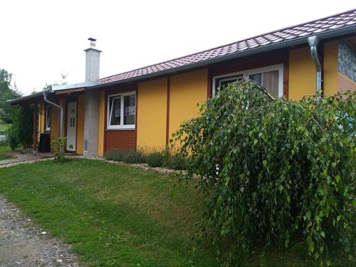 a yellow house with a tree in front of it at prázdninový domeček Zlámanka in Kroměříž