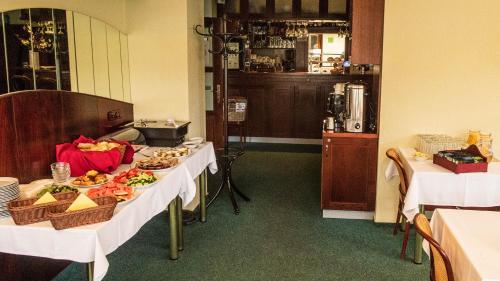 a room with two tables with plates of food at Penzion Rondo in Bystřice pod Hostýnem