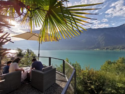 a group of people sitting at a table with a view of a lake at Hotel Brienzersee in Ringgenberg