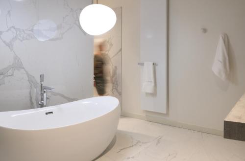 a bathroom with a white tub and a sink at Couvent de la Salette & Spa in Millau