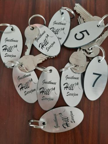 a bunch of key chains with handwriting on them at Guesthouse Hill in Sarajevo