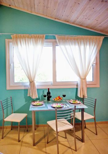 a dining room with a table and chairs and a window at Lazy Lizard in Néa Karváli