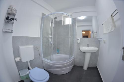 a bathroom with a shower and a toilet and a sink at Casa Robinson in Vama Veche