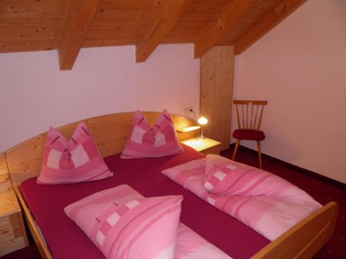 une chambre avec un lit avec des oreillers roses dessus dans l'établissement Flatscherhof, à San Lorenzo di Sebato