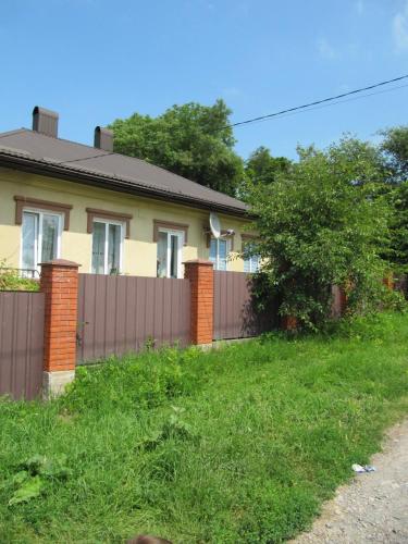 une maison avec une clôture dans la cour dans l'établissement вулиця Нагiрна, à Kamianets-Podilsky