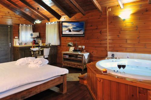 een badkamer met een bad, een bed en een wastafel bij Bikta Banof in Rosh Pinna