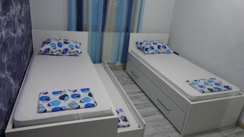 two beds in a room with blue and white pillows at Apartment Kraljica Jelena in Virpazar