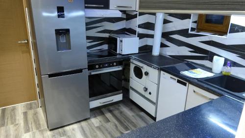 a kitchen with stainless steel appliances and black counter tops at Apartment Kraljica Jelena in Virpazar