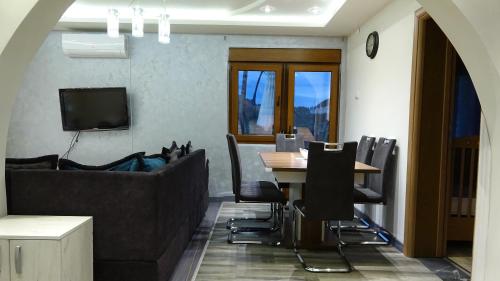a dining room with a table and black chairs at Apartment Kraljica Jelena in Virpazar