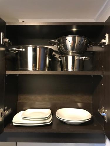 une cuisine avec deux assiettes et casseroles et des poêles dans l'établissement Departamento céntrico con vista, à San Carlos de Bariloche