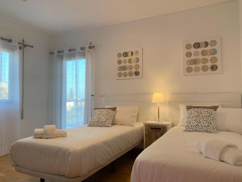 two beds in a room with white walls and windows at Penthouse 160sqm wide Terraces Pool view & private Hot Tub & Parking in Albufeira