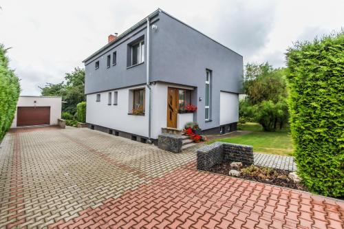 a white house with a brick driveway at Pension Milada in Klecany
