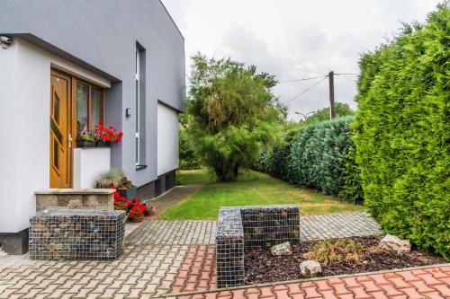 a house with a brick walkway in front of a yard at Pension Milada in Klecany
