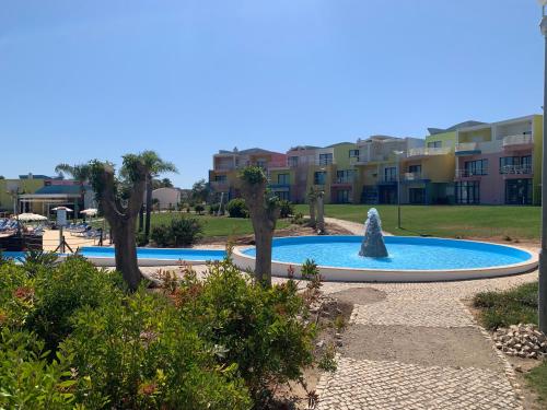 a fountain in the middle of a pool with buildings in the background at Penthouse 160sqm wide Terraces Pool view & private Hot Tub & Parking in Albufeira