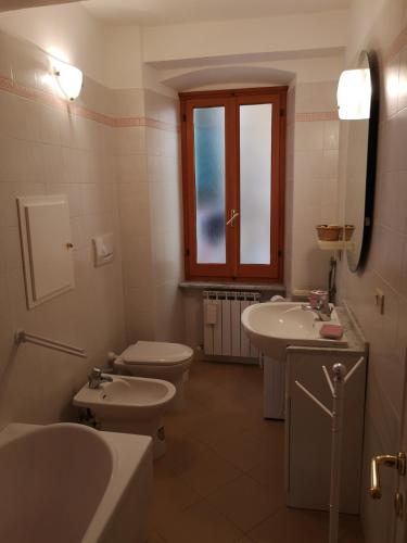 a bathroom with two toilets and two sinks and a window at Ca' dei Nogi - Appartamento a Riomaggiore in Riomaggiore