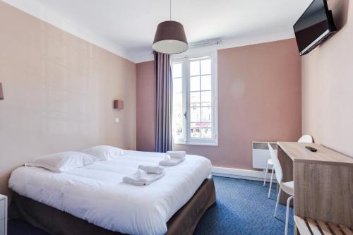 a bedroom with a bed and a desk and a window at Hôtel-Restaurant Le Blueberry in Malaucène