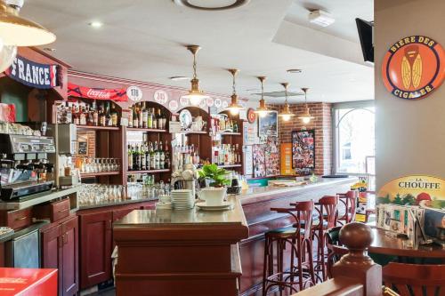 een bar met houten kasten en barkrukken bij Hôtel-Restaurant Le Blueberry in Malaucène