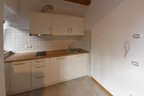 得利雅斯特的住宿－Agriturismo Kralj，厨房配有白色橱柜和水槽