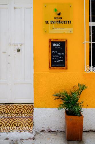 a yellow building with a sign on the side of it at Hostal Españolete in Santa Marta