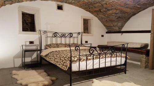 a bedroom with a black bed and a stone wall at Wine cellar room in Vipava