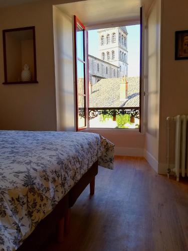 une chambre avec un lit et une grande fenêtre dans l'établissement LA MAISON DE MARION, à Tournus