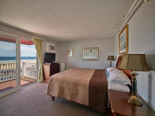 Habitación de hotel con cama y balcón en Atlantic Sands en Hampton Beach